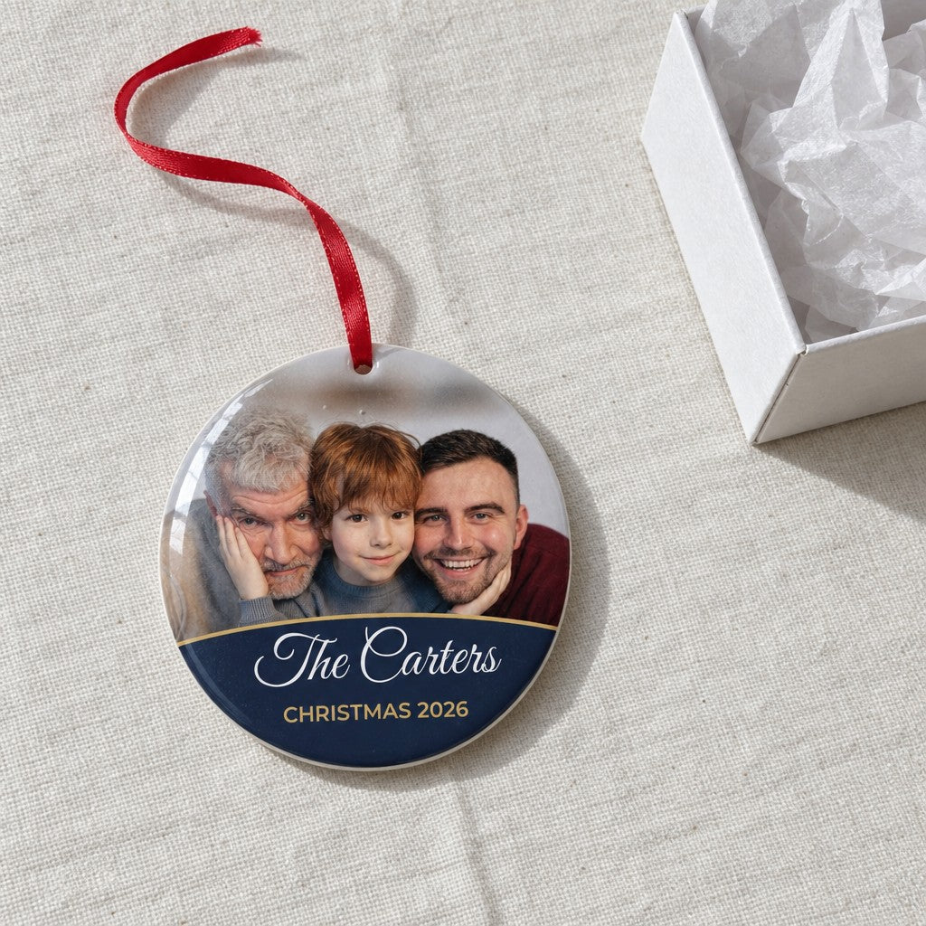 Midnight blue personalised family photo bauble on a tablecloth beside a white gift box