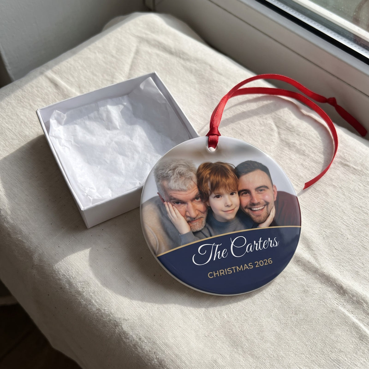 Midnight blue personalised family photo bauble hanging by a window