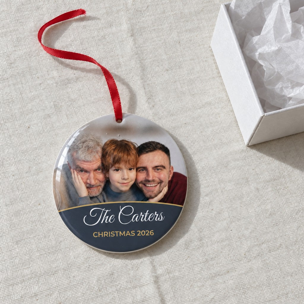 Slate personalised family photo bauble on a tablecloth beside a white gift box