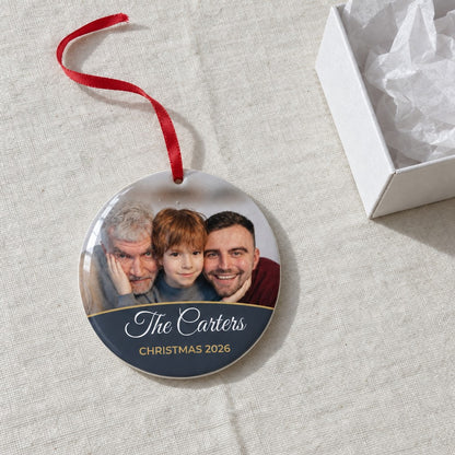 Slate personalised family photo bauble on a tablecloth beside a white gift box