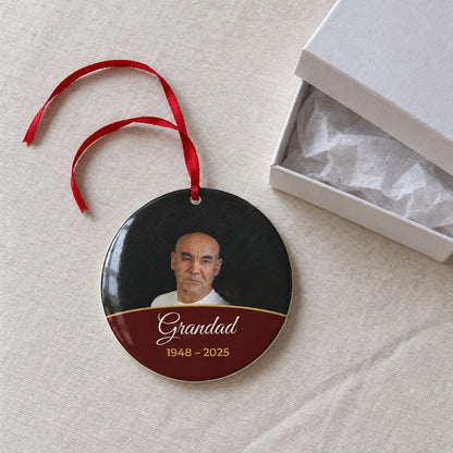 Berry red personalised memorial photo bauble on a tablecloth beside a white gift box