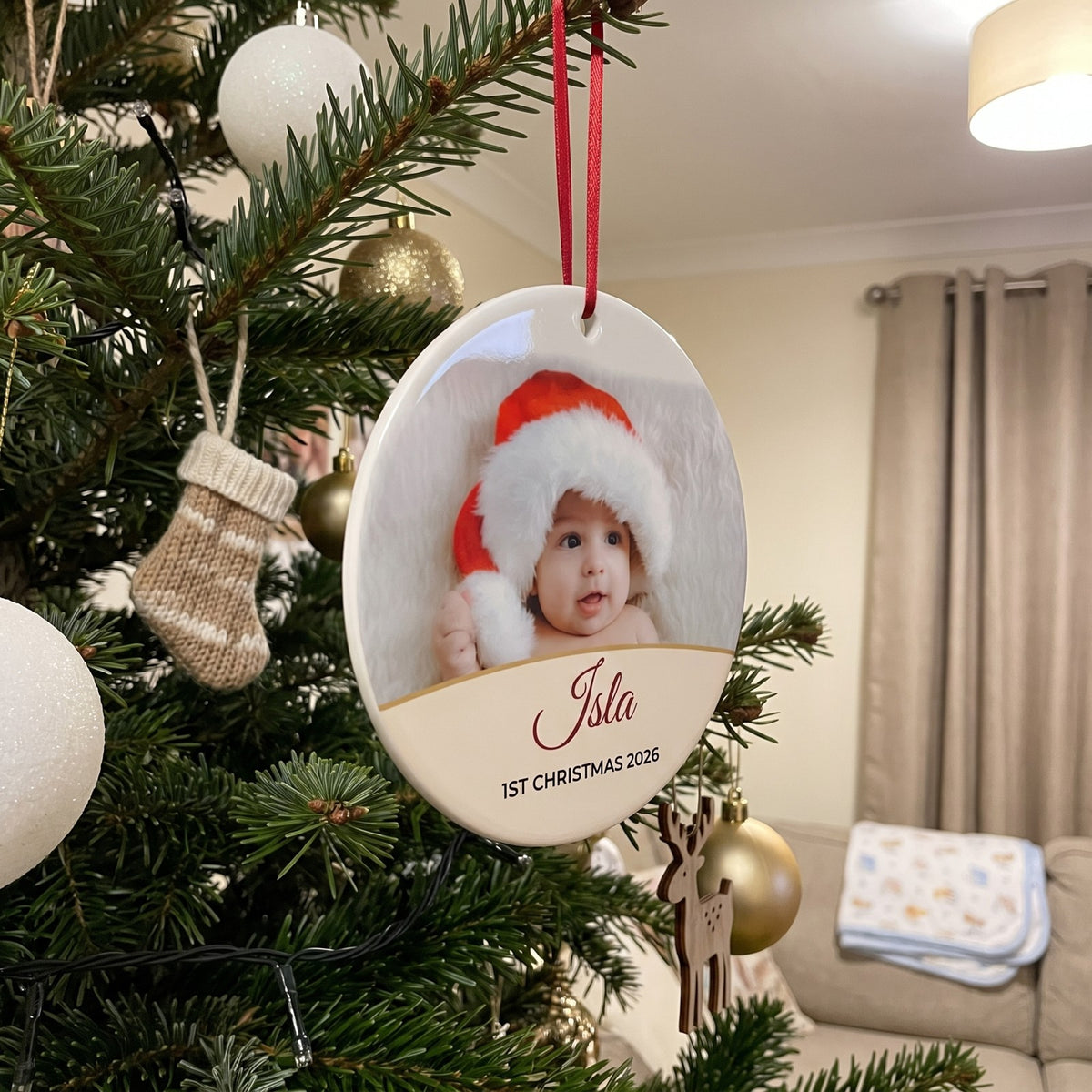 Cream personalised Baby's 1st Christmas photo bauble hanging on a Christmas tree
