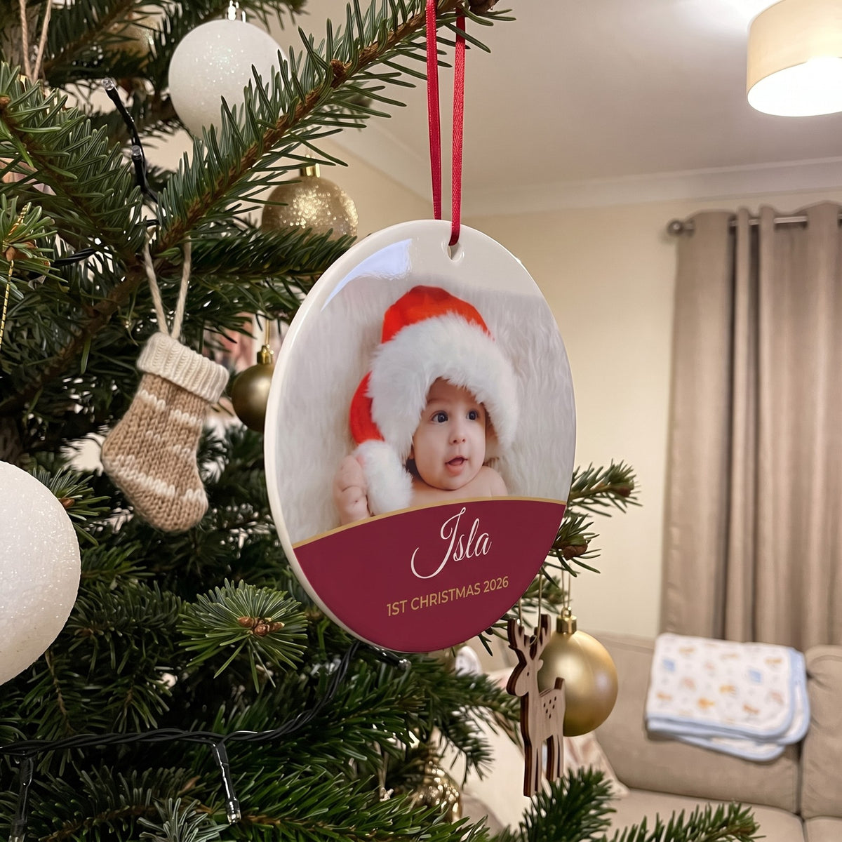 Berry red personalised Baby's 1st Christmas photo bauble hanging on a Christmas tree