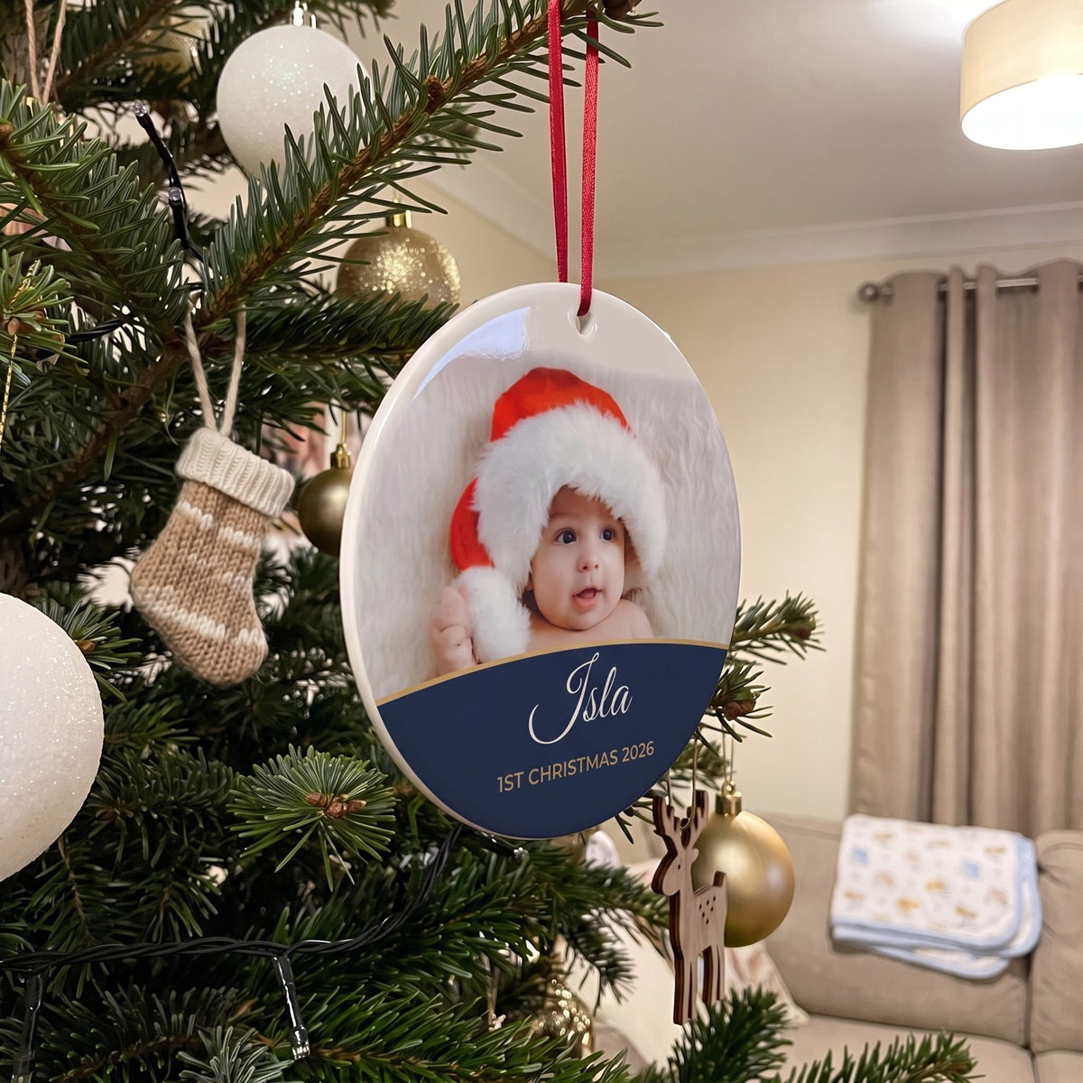 Midnight blue personalised Baby's 1st Christmas photo bauble hanging on a Christmas tree