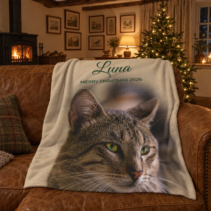 Cream personalised photo blanket with a tabby cat and the name Luna, draped over a leather sofa in a cottage living room